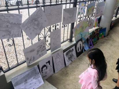 A young girl views art created by local students.